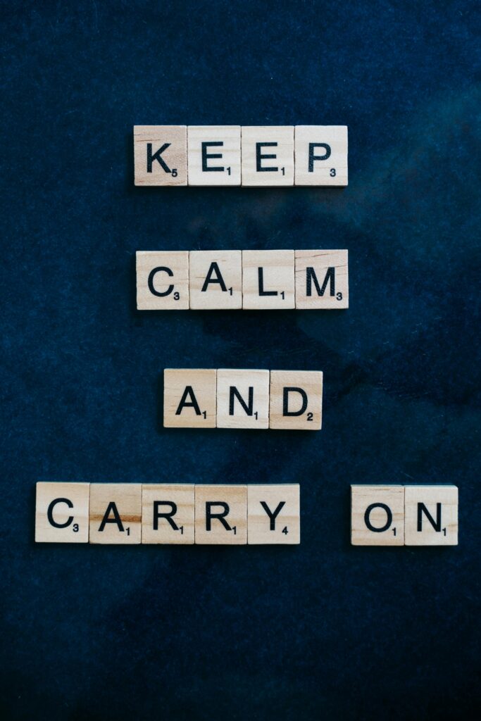 pexels-photo-8051951-8051951 Scrabble tiles spelling 'Keep Calm and Carry On' on a dark surface for inspiration.