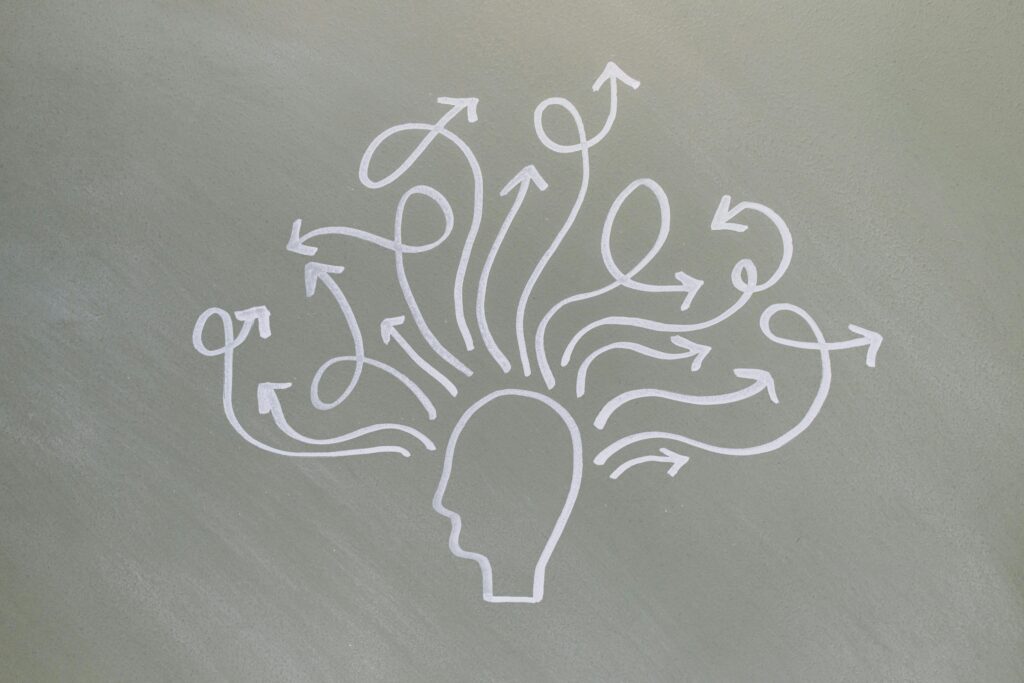 Conceptual chalk drawing illustrating mental health challenges with arrows representing thoughts.