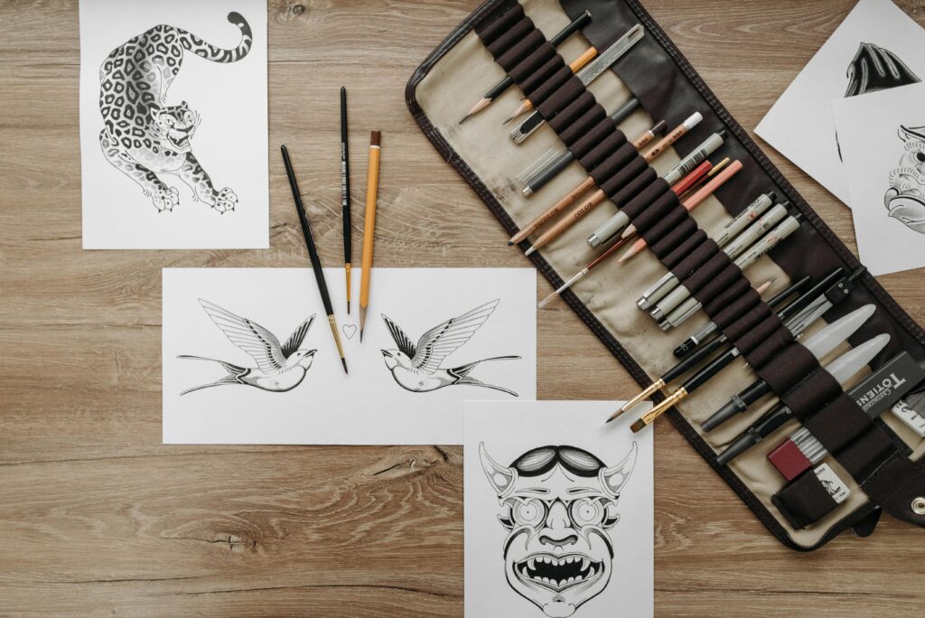 Flat lay of tattoo design sketches and art supplies for artistic inspiration and creativity.